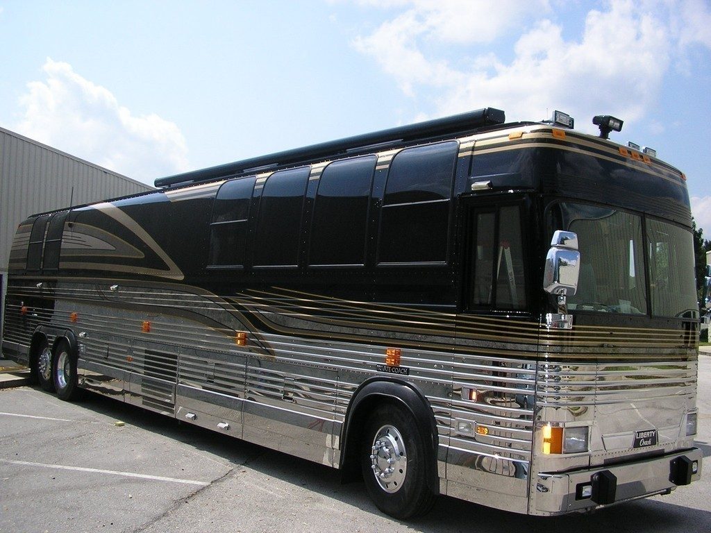 Prevost motorhome with a patio awning and fairing added by Excalibur Coach