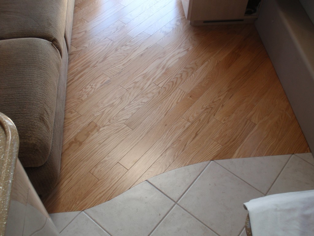 Prevost H3-45 XLII Motorhomes Class A - New wood floor in salon showing transition to galley by Excalibur Coach